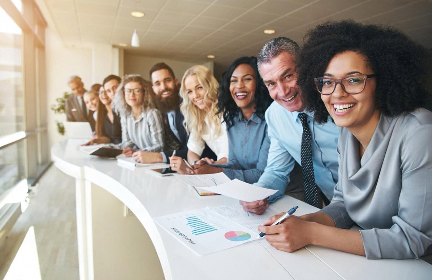 Engaged UAE employees collaborating around a meeting table with reports and charts